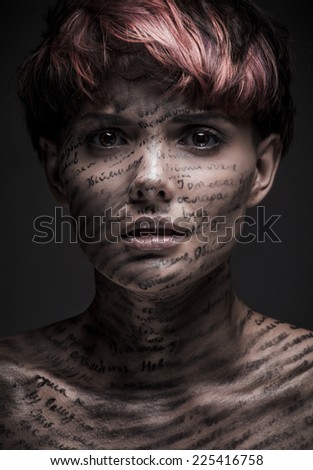 Portrait of scared or frightened girl with writing and erased text on her body