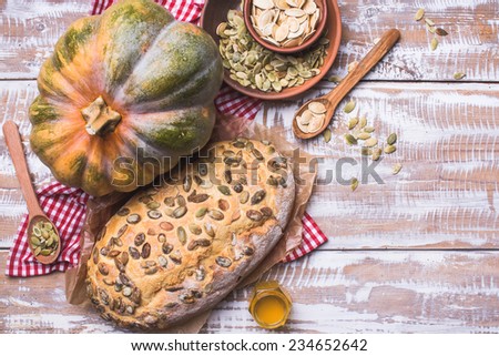 White bread with pumpkin seeds on wooden table in rustic style. food photo