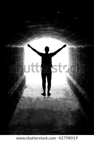 Human silhouette in back lighting in tunnel exit