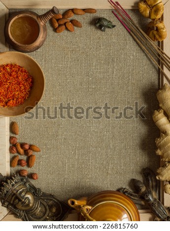 Indian figurines, saffron, figs, nuts, incense and ginger with a recipe template on a sackcloth in the frame