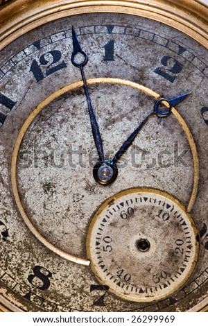 Picture of the grungy face of a very old and dirty pocket watch with one slightly bent hand and a missing second hand
