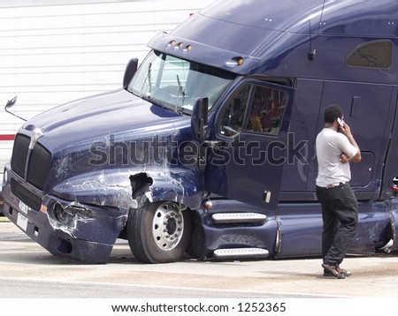 A man makes a call on his cell phone after his tractor trailer jackknifed during a collision with an SUV on I-35 in Texas.
