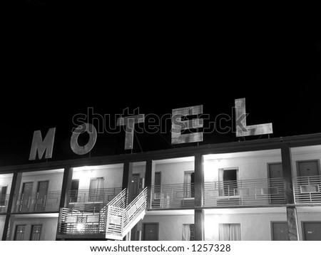A creepy old motel sign in black and white.