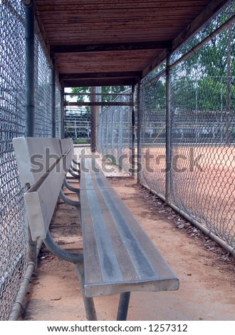 A empty dugout at an empty baseball field.