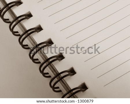 A spiral bound notebook up close, black and white.