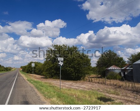 Stock photo of a Texas Farm Road highway sign with an empty stretch of road stretching off into the distance.