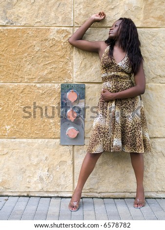 A fashionable young African American woman in a leopard print dress.