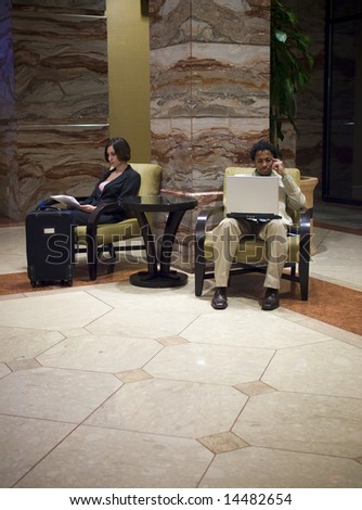 Hotel guests waiting in an upscale hotel lobby.