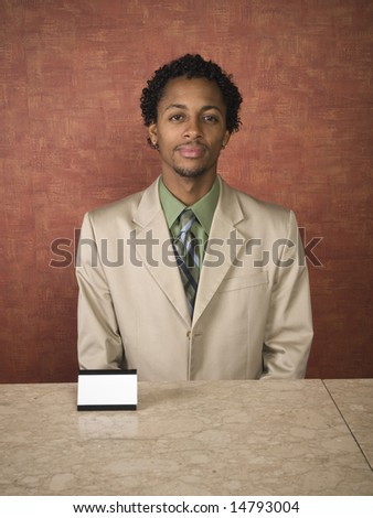 A hotel employee cheerfully welcomes guests.