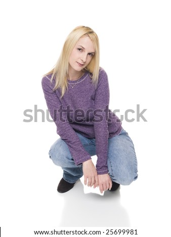 Isolated studio shot of a woman crouching down on the floor and looking at the camera.