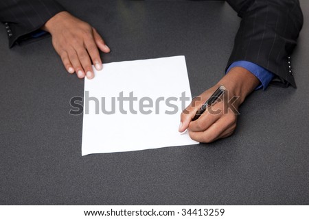 Isolated studio shot of a businessman\'s hands pointing to the end of a blank page ready for your copy.