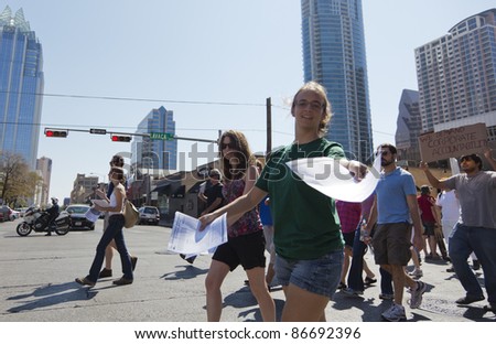 AUSTIN, TX - OCTOBER 15: An unidentified woman distributes information about credit unions during the \'Occupy Austin\' march to the Texas State Capitol on October 15, 2011 in Austin.