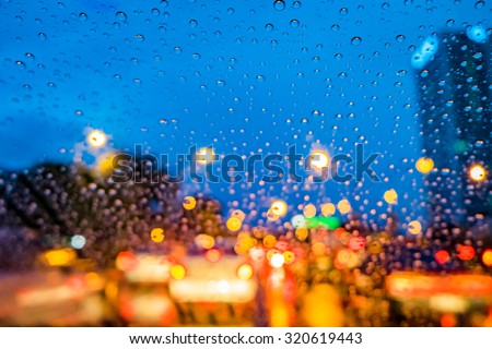 Image of raindrops on window at night in the city. Street Bokeh Lights defocused.