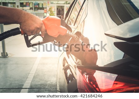 Car refueling on petrol station. To fill the machine with fuel at pump. Man pumping gasoline on car at gas station.