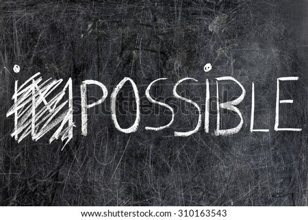 Impossible becomes possible handwritten with white chalk on dirty blackboard