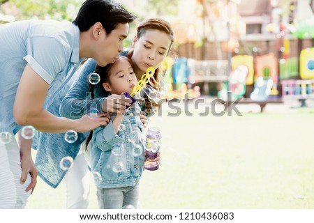 Asian family is playing balloon bubbles in the park, which is ideal for long weekend vacations. Taking care of family makes children feel the love of parenting. Family health insurance is a good plan.