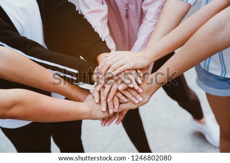 Close up at the hands many teenage girls. Show unity as a collaborative work together. To succeed, one has to understand each other in communication. Concept International Women\'s Day