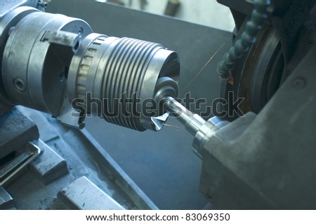 Machining lathe turning steel in a manufacturing plant