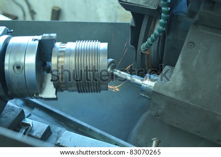 Machining lathe turning steel in a manufacturing plant