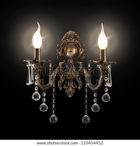 Elegant bronze wall sconce with glass crystals in light