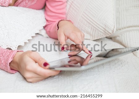 Woman\'s finger touching screen of mobile device and choosing something in internet shop or social network