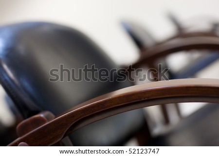 Soft chairs of black leather standing in row for seminar or business activities