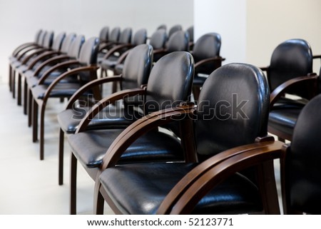 Soft chairs of black leather standing in row for seminar or business activities