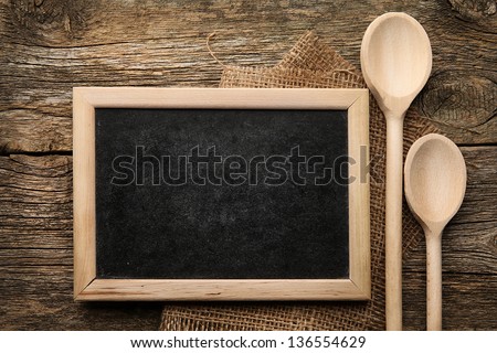 Blackboard On Wooden Surface And Serving Spoons