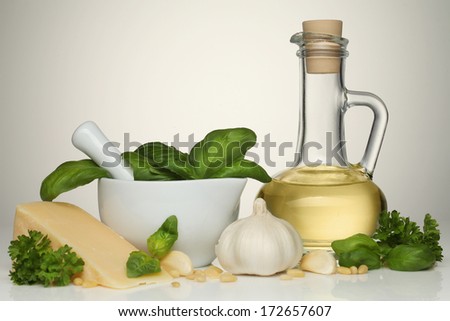 Bowl of pesto genovese sauce with ingredients. oil, parmesan cheese, garlic, pine nuts and basil
