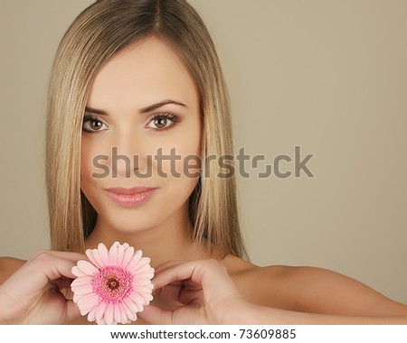 stock photo Young blond woman with pink flower in her hand