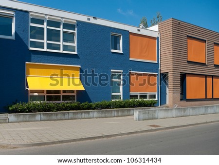 modern building with yellow and orange sunshades on a hot day