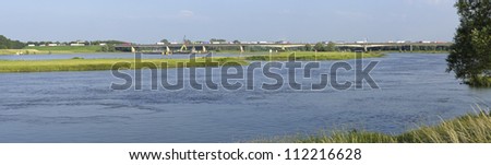 panoramic view of the IJssel river at Deventer in the Netherlands. In the background a large highway bridge with traffic
