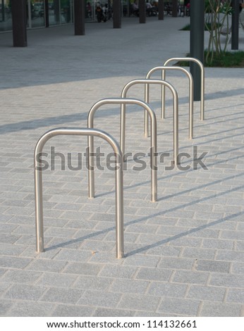 simple metal bicycle racks in front of a shopping mall