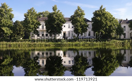 row of white residential houses reflected in a canal