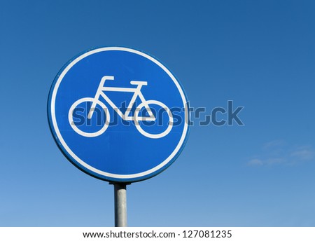 round bicycle lane sign against a blue sky