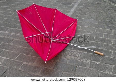 abandoned red umbrella broken by the wind