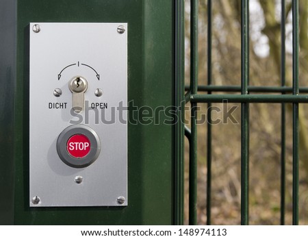 lock with stop button on a green metal gate