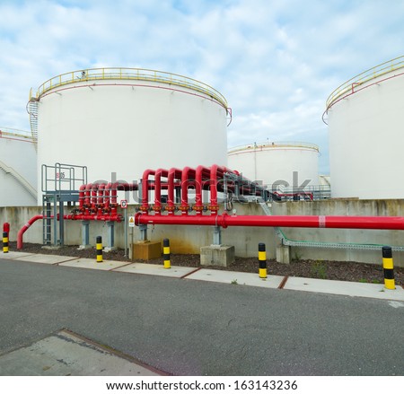 large storage tanks for oil and petrol in the amsterdam harbor area. The red pipelines are for water supply in case of an fire emergency