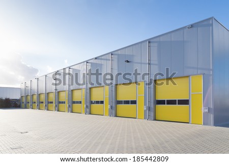 exterior of a commercial warehouse with yellow roller doors