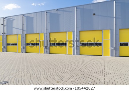 exterior of a commercial warehouse with yellow roller doors