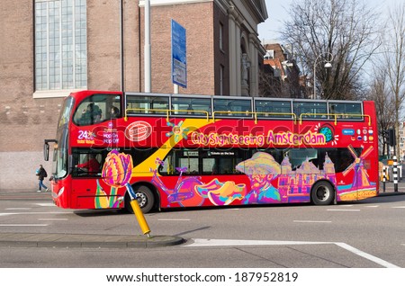 AMSTERDAM - FEBRUARY 23, 2014: Citysightseeing Amsterdam tourist bus with panoramic roof. It offers tourists a hop on - hop off service at 12 points of interest in the city.