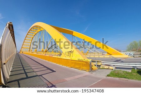 yellow arch bridge in Utrecht, netherlands. The Hogeweide Bridge is a steel arch bridge over the Amsterdam-Rhine Canal