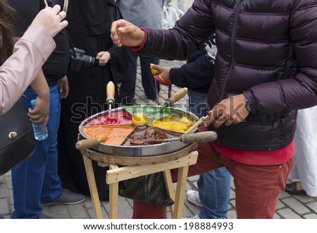 vendor selling multi-colored caramel on a stick