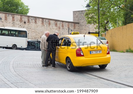ISTANBUL - APRIL 27, 2014: Two unknown men negotiating with a taxi driver. In Istanbul there are almost 20,000 taxis, most of them powered by clean LPG propane gas