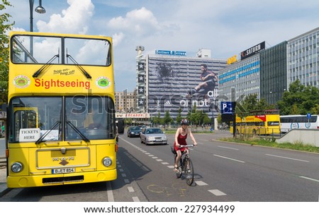 BERLIN - JULY 27, 2014: Yellow city sightseeing bus in Berlin. It\'s a hop-on/hop-off system where tourists can join the tour at any of the 18 stops along the route