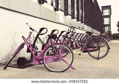 two pink bicycles parked outside a train station