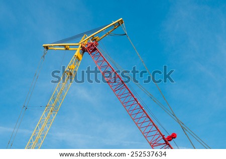 yellow and red crane connected at their top