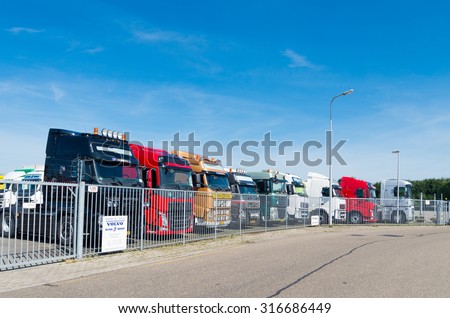 OLDENZAAL, NETHERLANDS - AUGUST 1, 2015: Row of used volvo trucks for sale behind a gate.  Volvo is the world\'s second largest heavy-duty truck brand.