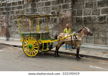 MANILA, PHILIPPINES - JUNE 7, 2015: Unknown man with horse drawn carriage in Intramuros, the monumental spanish part of Manila