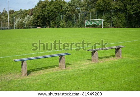 two empty benches along a soccer field